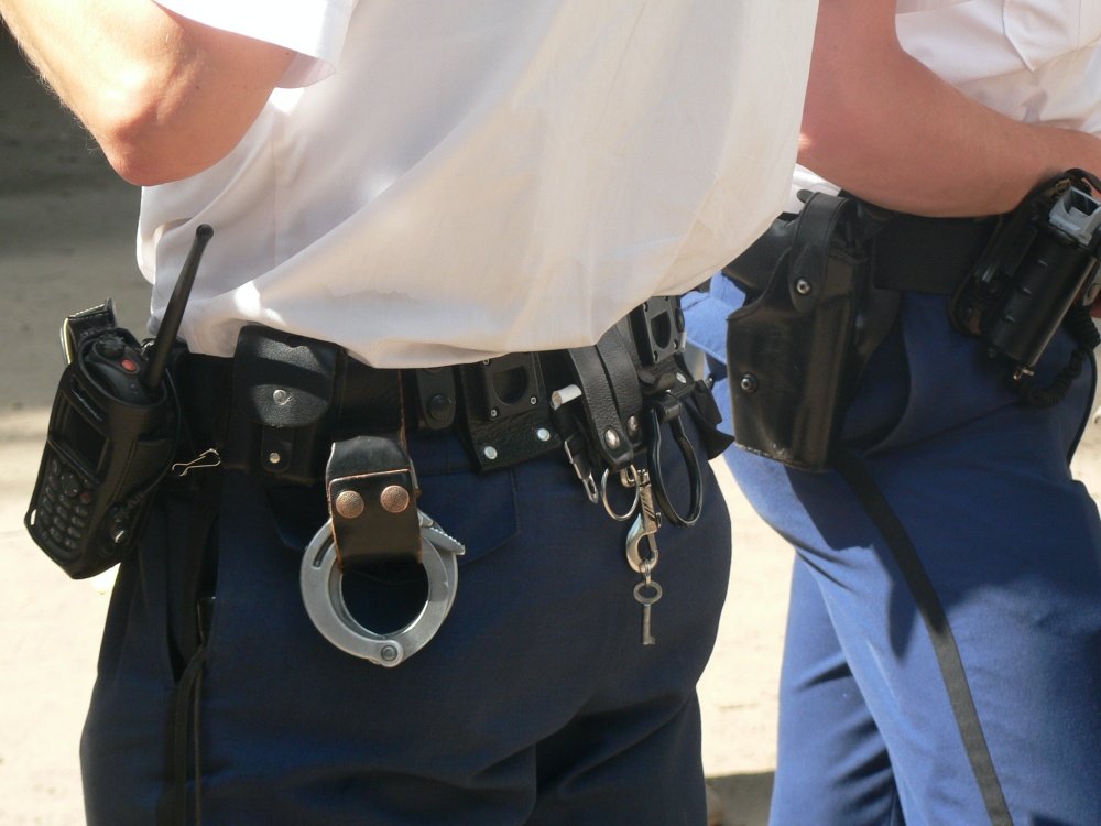 Policia con sus grilletes en el cinturón policial
