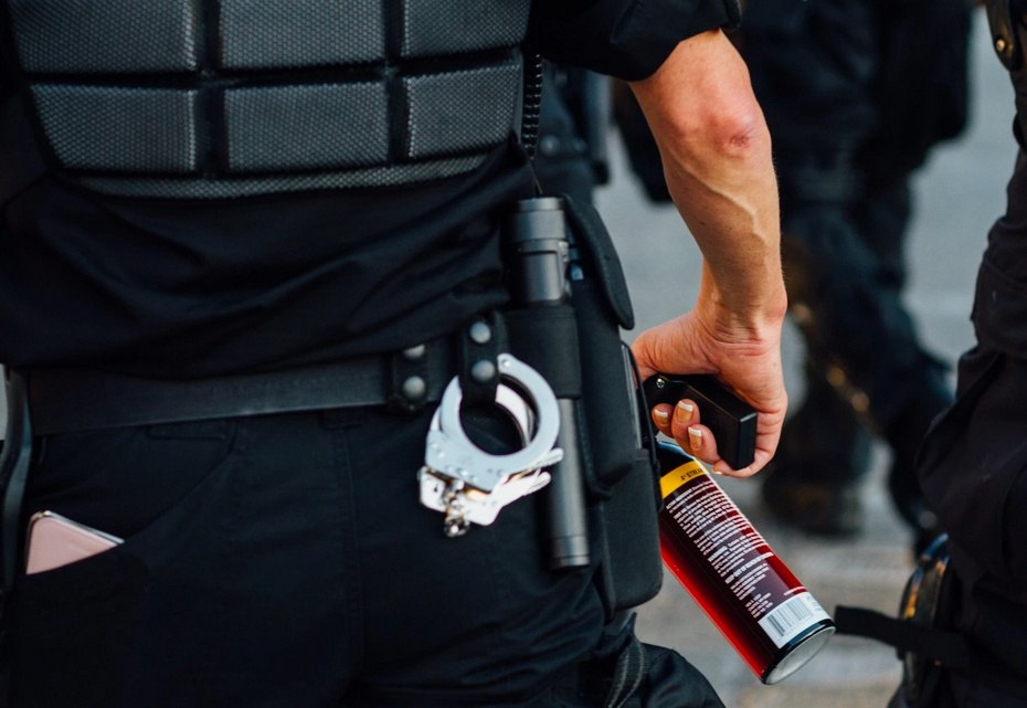 Policía con spray de pimienta para antidisturbios